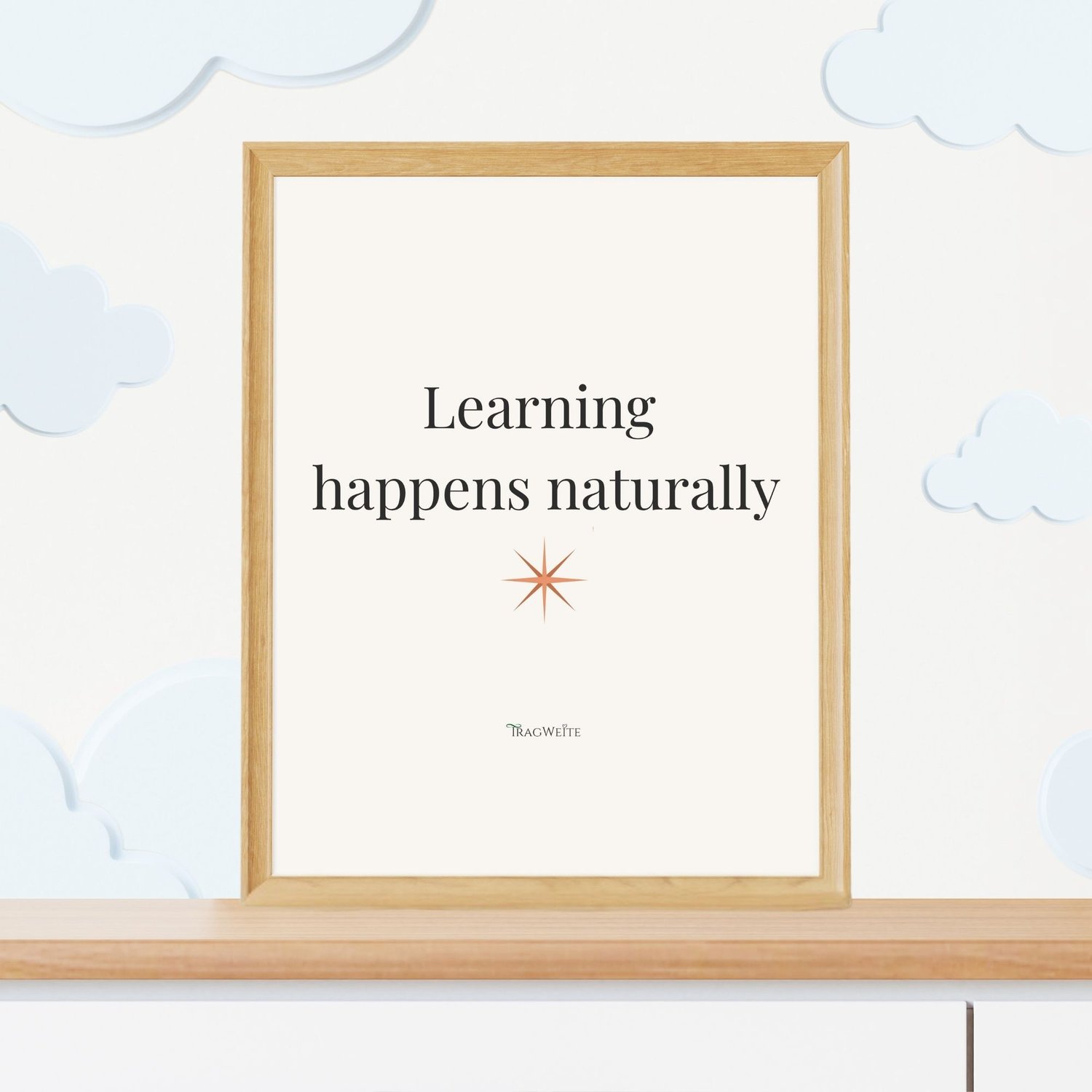 Framed printable poster "Learning happens naturally" with terracotta star, displayed in a childrens room. Minimalist wall art by Tragweite for conscious parents. Gerahmtes Poster „Lernen geschieht natürlich" mit terrakottafarbenem Stern im Kinderzimmer.