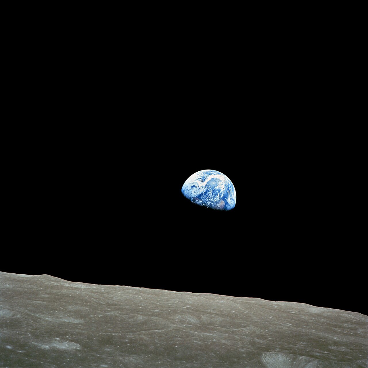 An image of Earthrise taken from the moon, the surface of which can be seen in the foreground. It was taken by NASA astronaut Bill Anders.