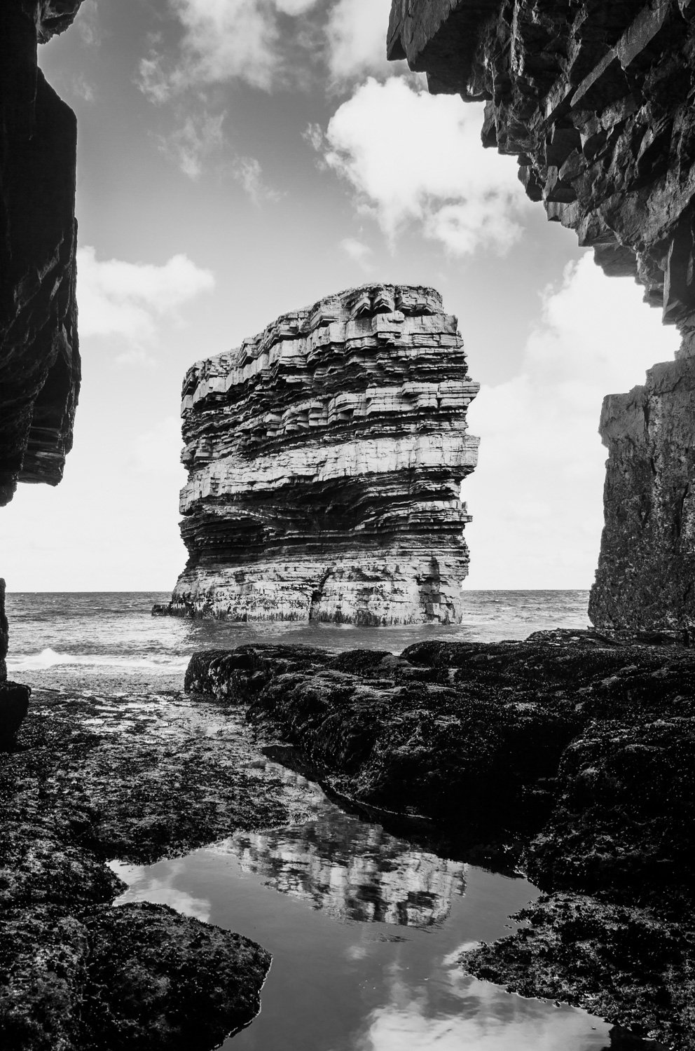 dun briste sea stack in black and white, taken from inside the sea cave