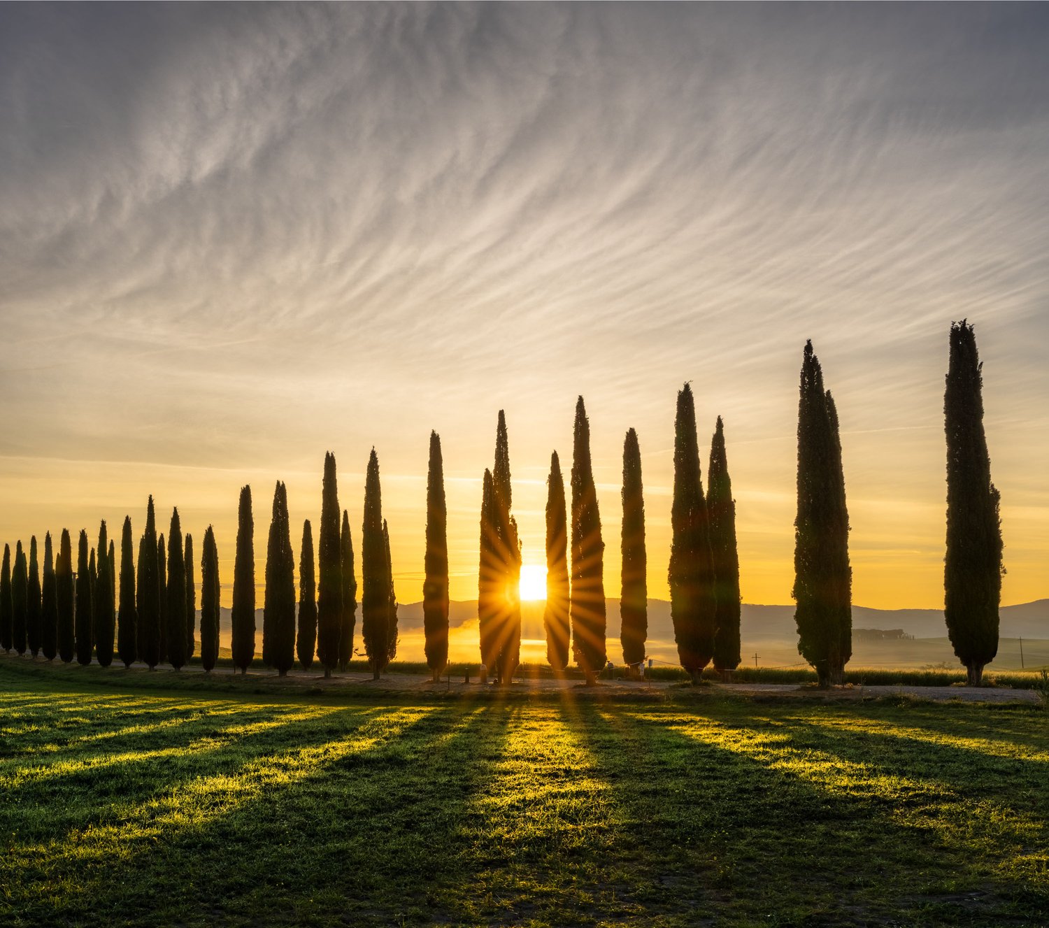 Tuscany Poggio Covili 2026 farmhouse sunrise cypress trees row clouds sun star