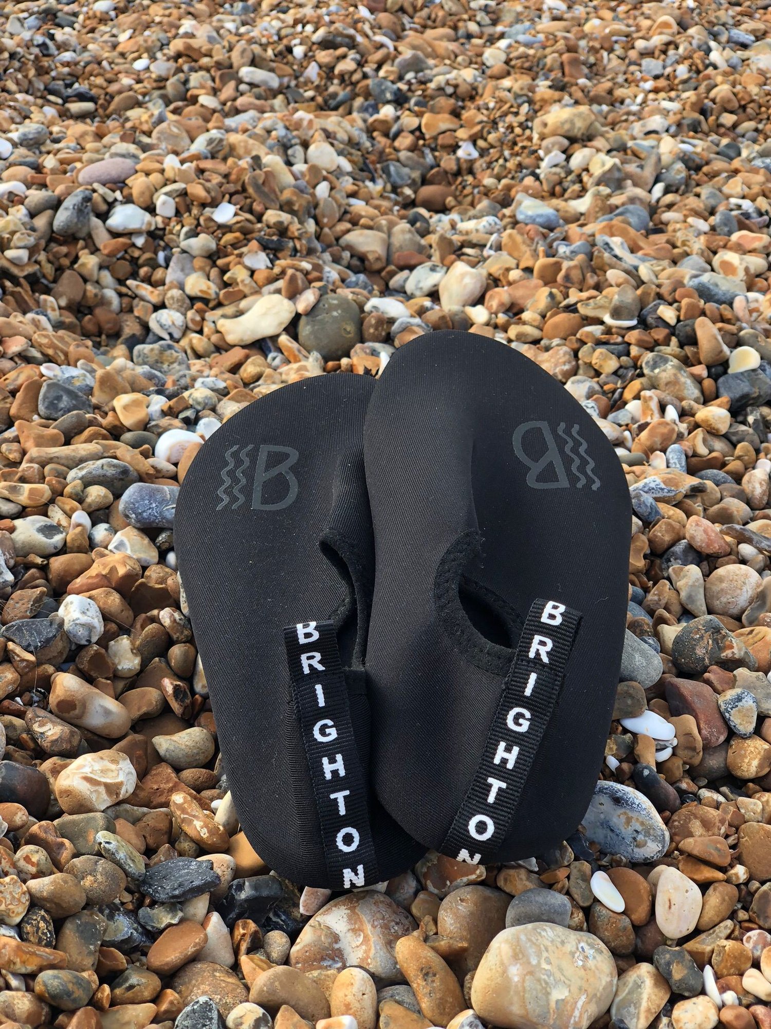 Black water shoes on a on a stony beach