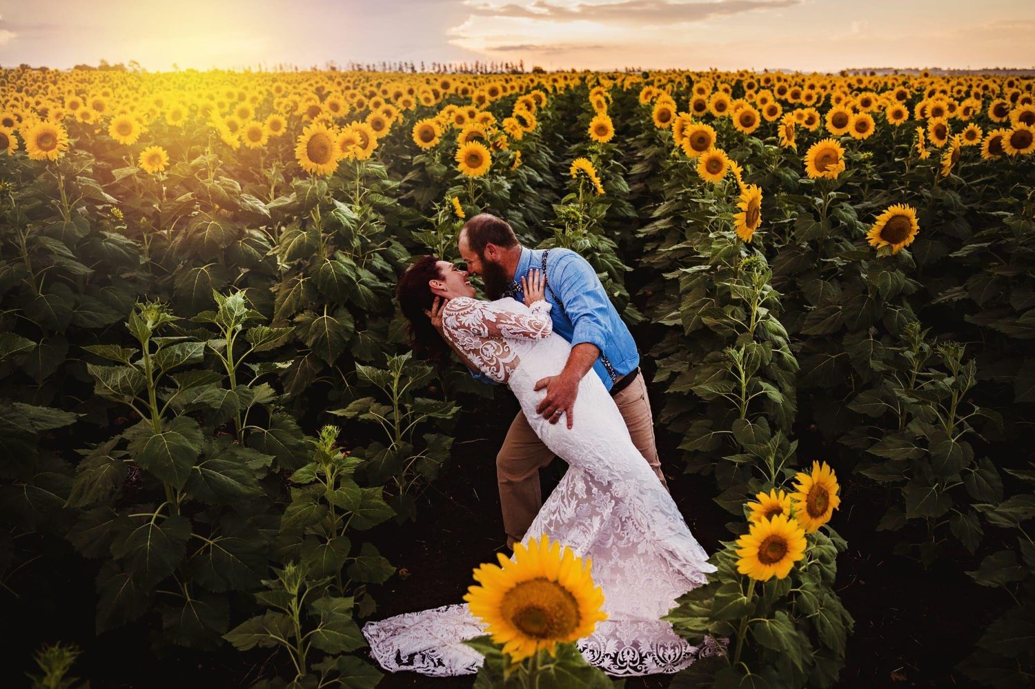 Bride and groom's first kiss on a sunflower farm