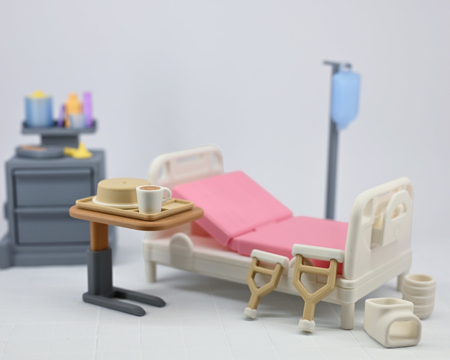 A miniature toy hospital bed next to many medical toy accessories