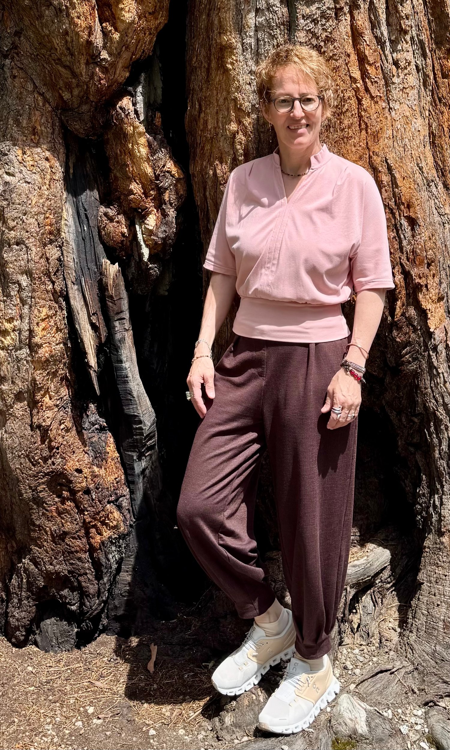 Tanja Hostettler beside a giant sequoia tree in nature. Founder of Solareya, guiding people through the Twin Flame Journey, awakening, remembrance, and inner transformation.