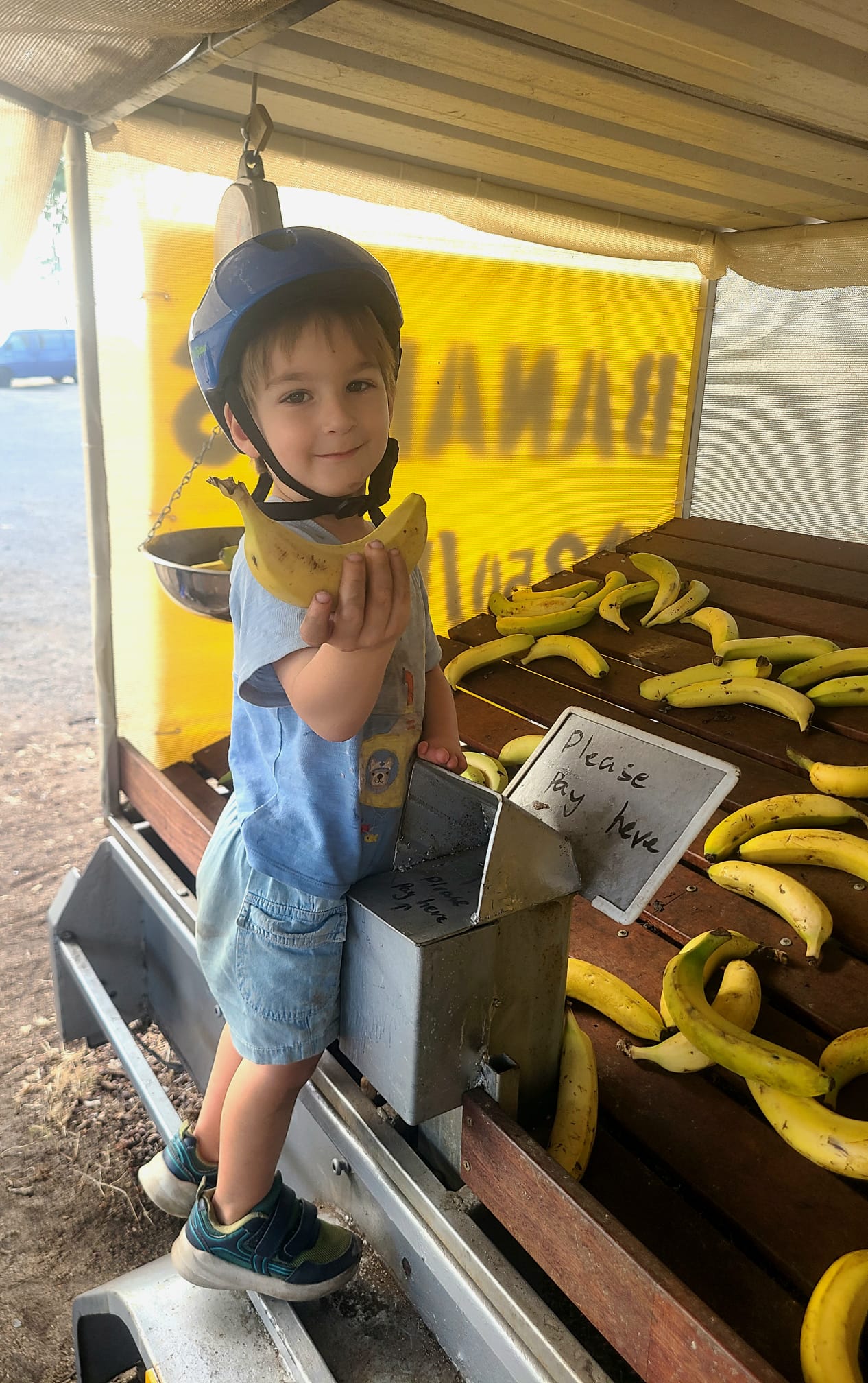 Boy holding banana at roadside stall