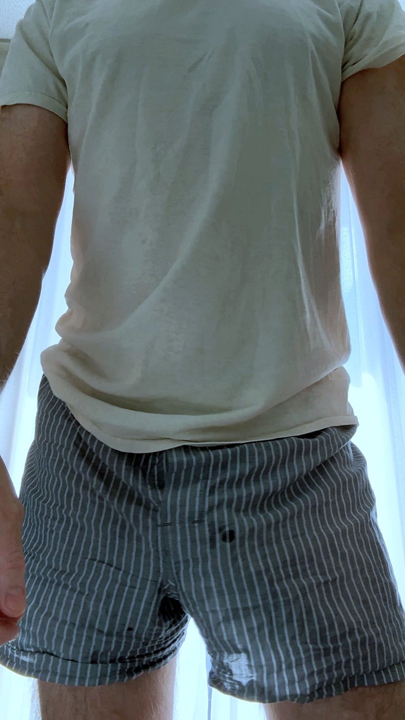 PRiCE Douglas wearing a white T-shirt and gray striped boxer shorts in natural window light, photographed for a visual diary about masculine ritual, comfort, and everyday clothing.
