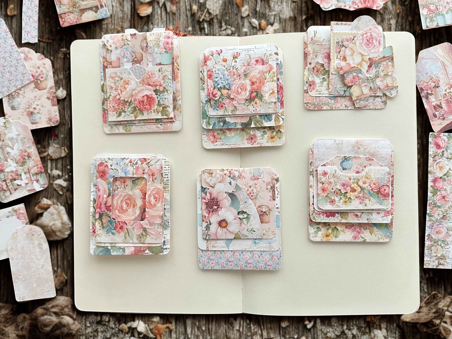 Flat lay display of assembled floral hidden paperclips clipped onto an open junk journal page.