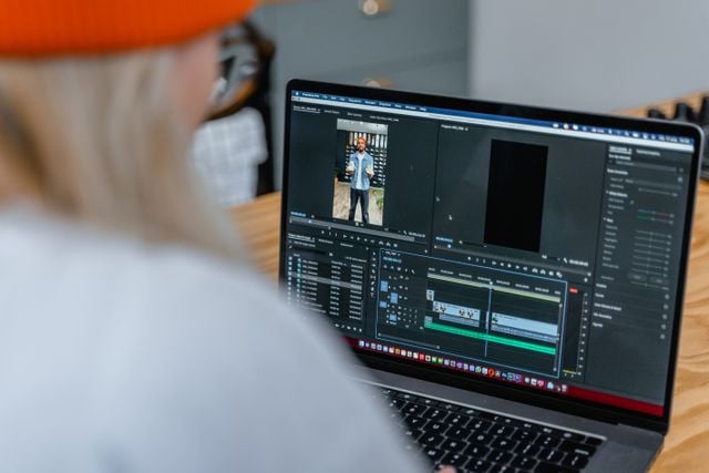 Monteur vidéo qui modifie une vidéo sur son ordinateur portable sur Adobe Premiere Pro