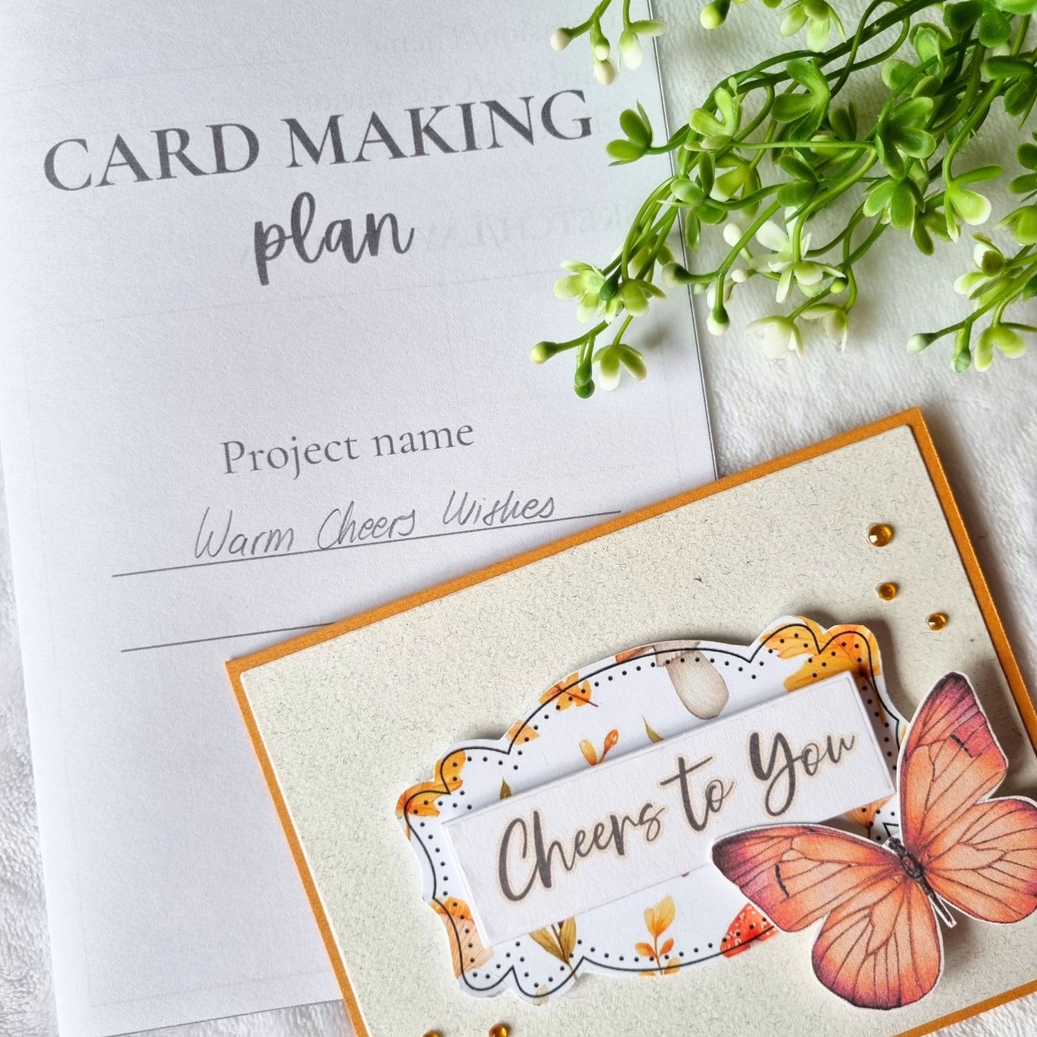 Card making for beginners: Handmade greeting card with butterfly next to a card making planner