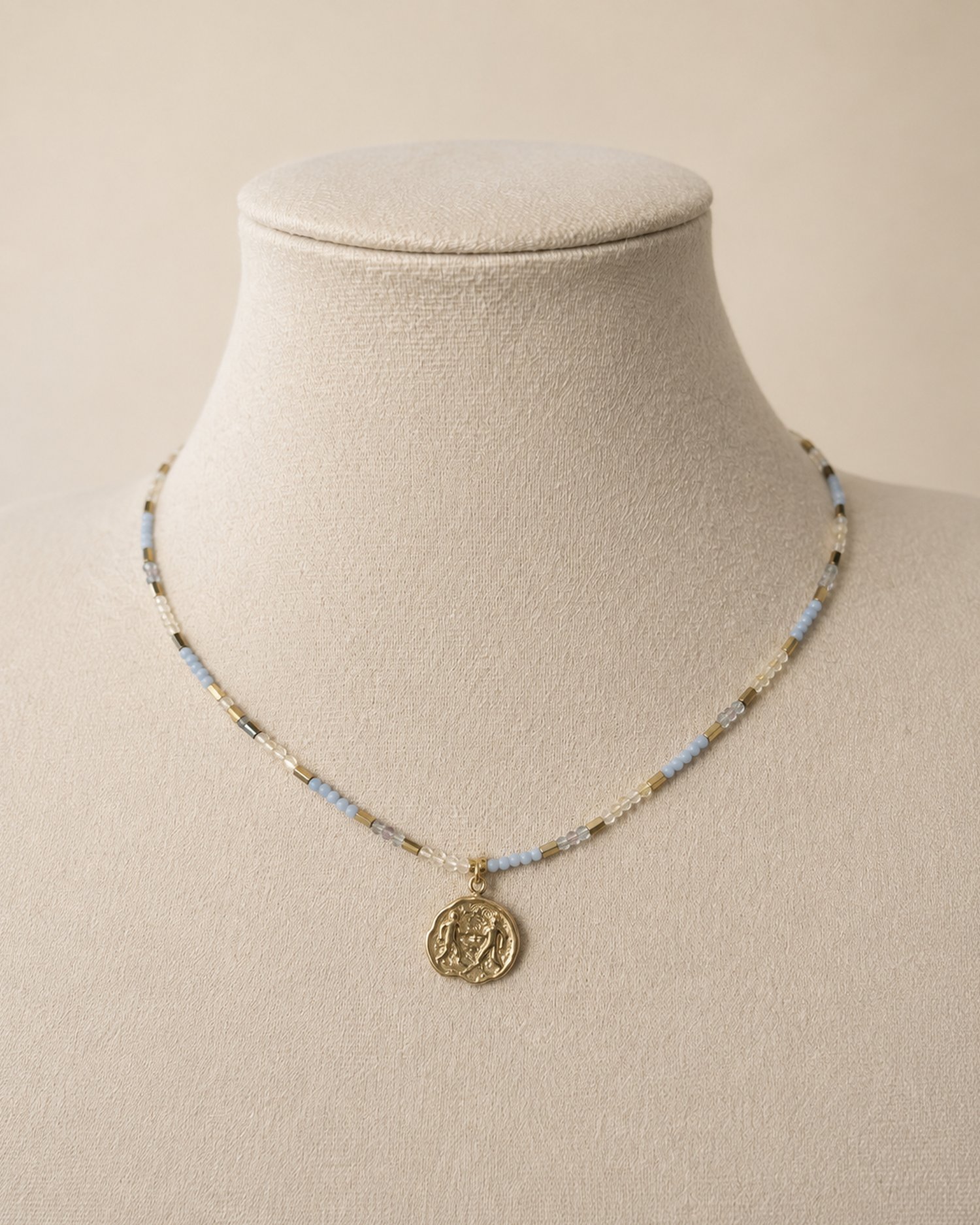 Collana Gemelli in agata blu, citrino e fluorite con ciondolo dorato su manichino