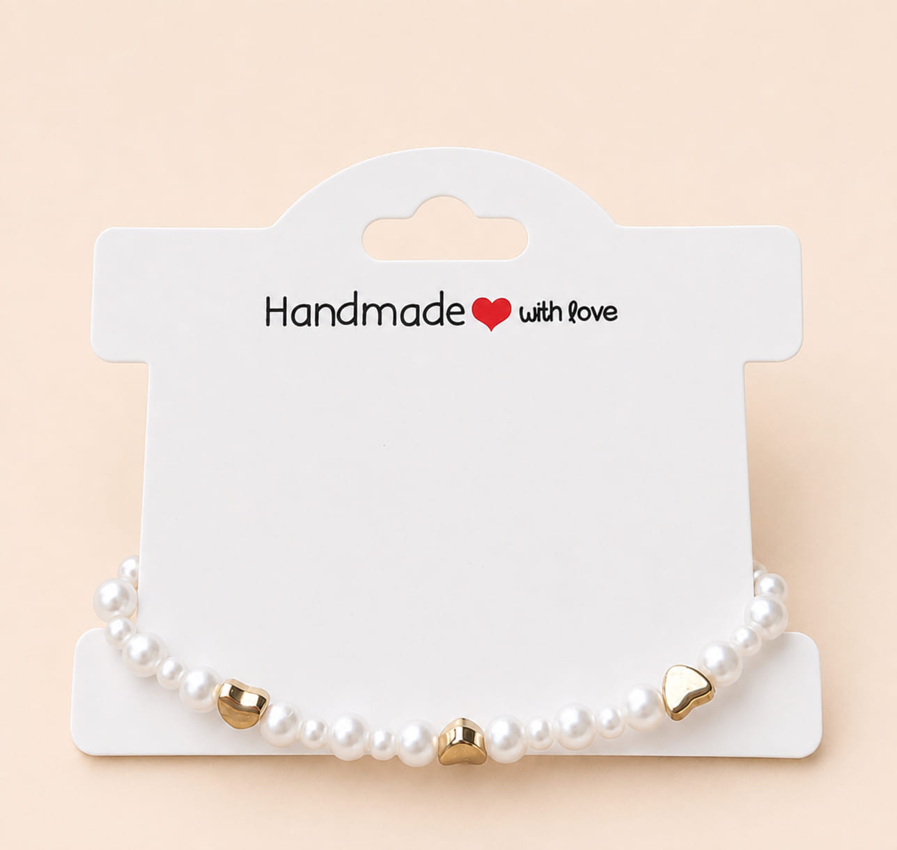 Pearl and gold heart bracelet presented on a Handmade with love jewellery display card