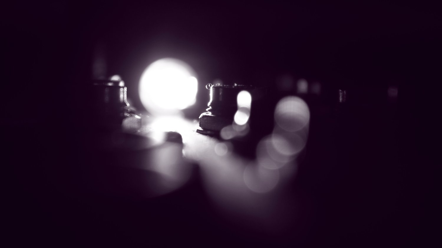 A captivating abstract image featuring bokeh effects and a central illuminated glow in a dark setting.