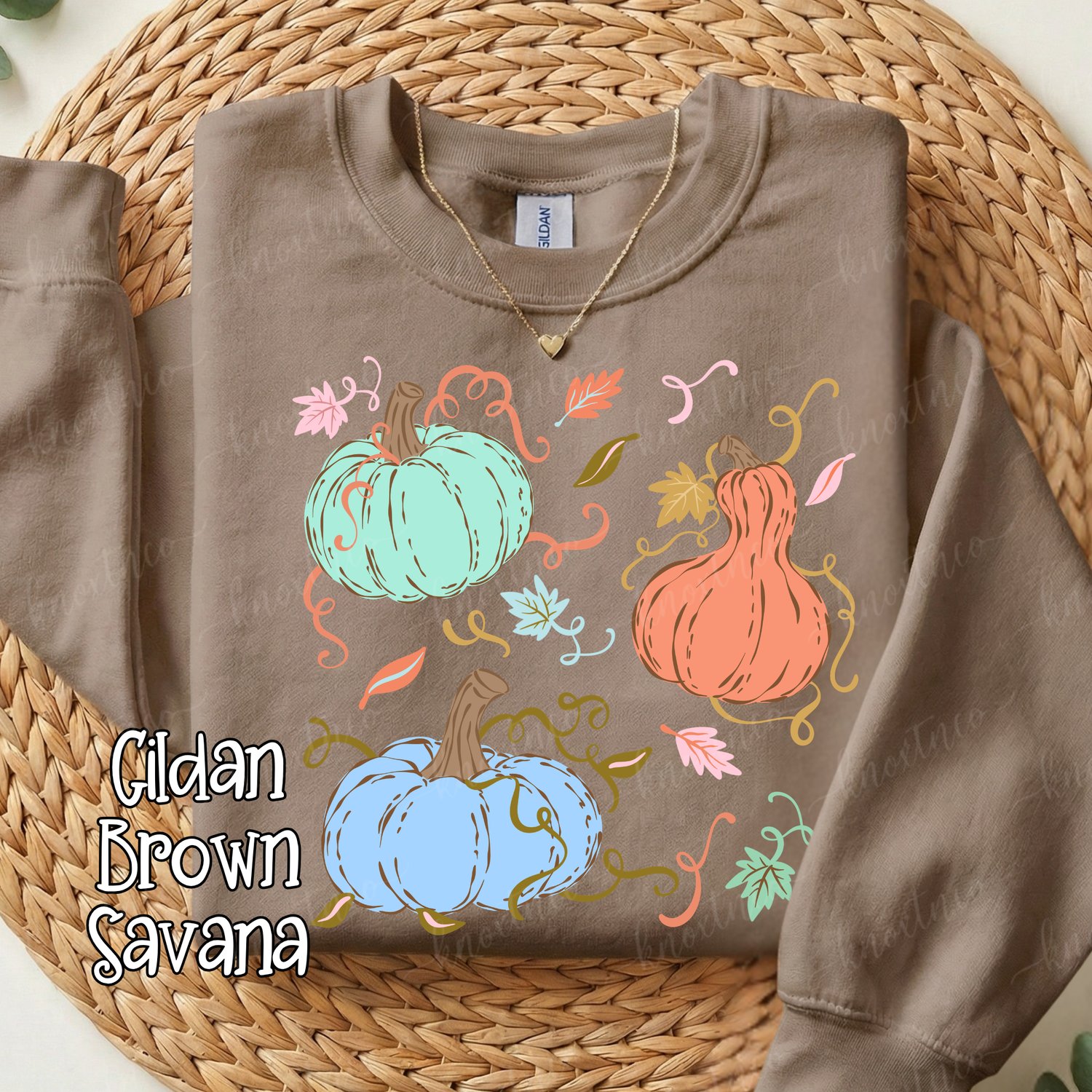 Brown Gildan Sweatshirt featuring three colorful whimsical pumpkins in mint green, peach, and light blue with fall leaves and curly vines, styled for autumn and pumpkin season.