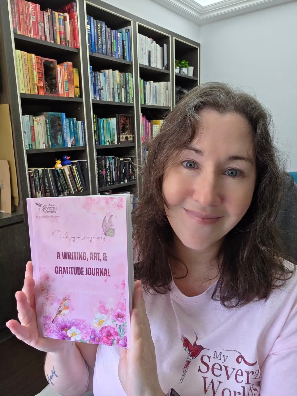 Carrie Marshall poses with her latest publication in her home office and library.