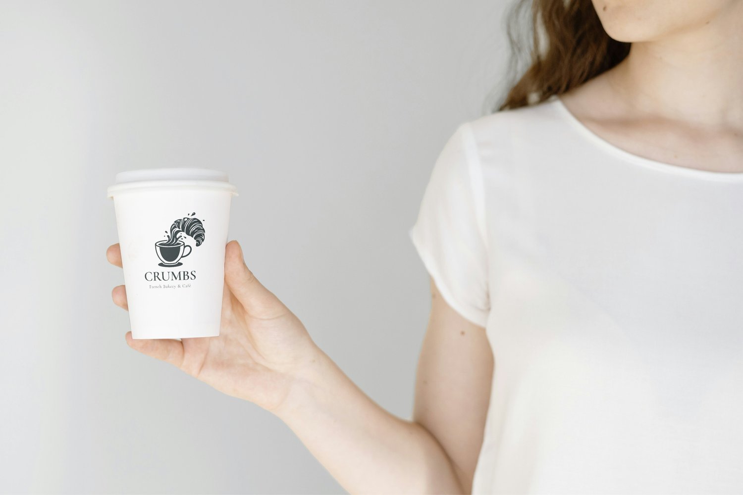 Paper coffee cup mockup with custom logo held in hand