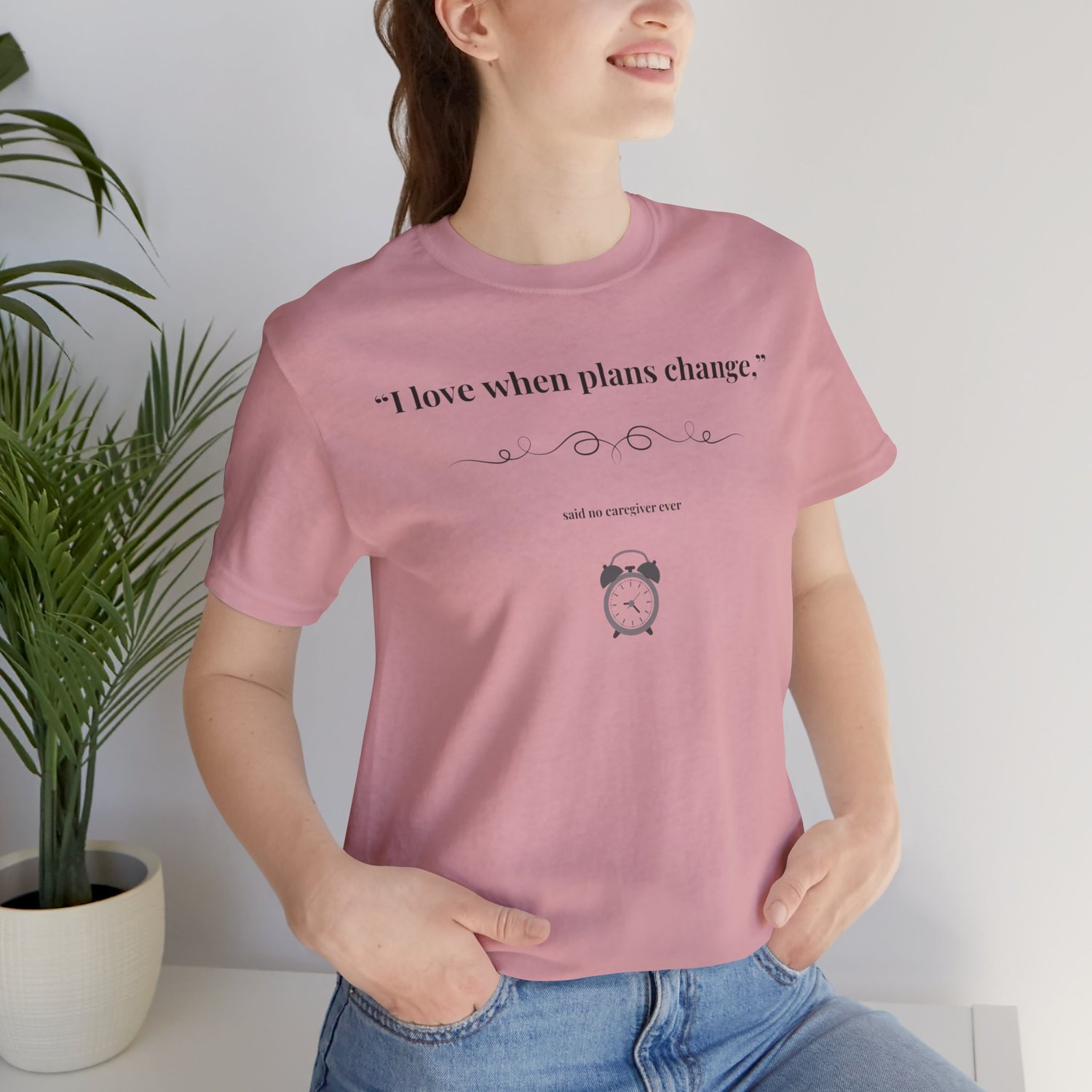 Woman wearing Orchid caregiver tee with "I Love When Plans Change" design