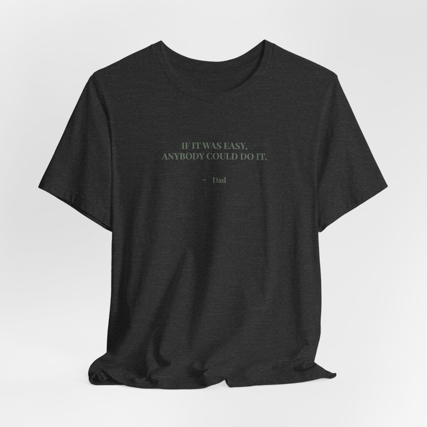 Gray t‑shirt laid flat with natural wrinkles, showing the quote ‘If it was easy, anybody could do it. — Dad.