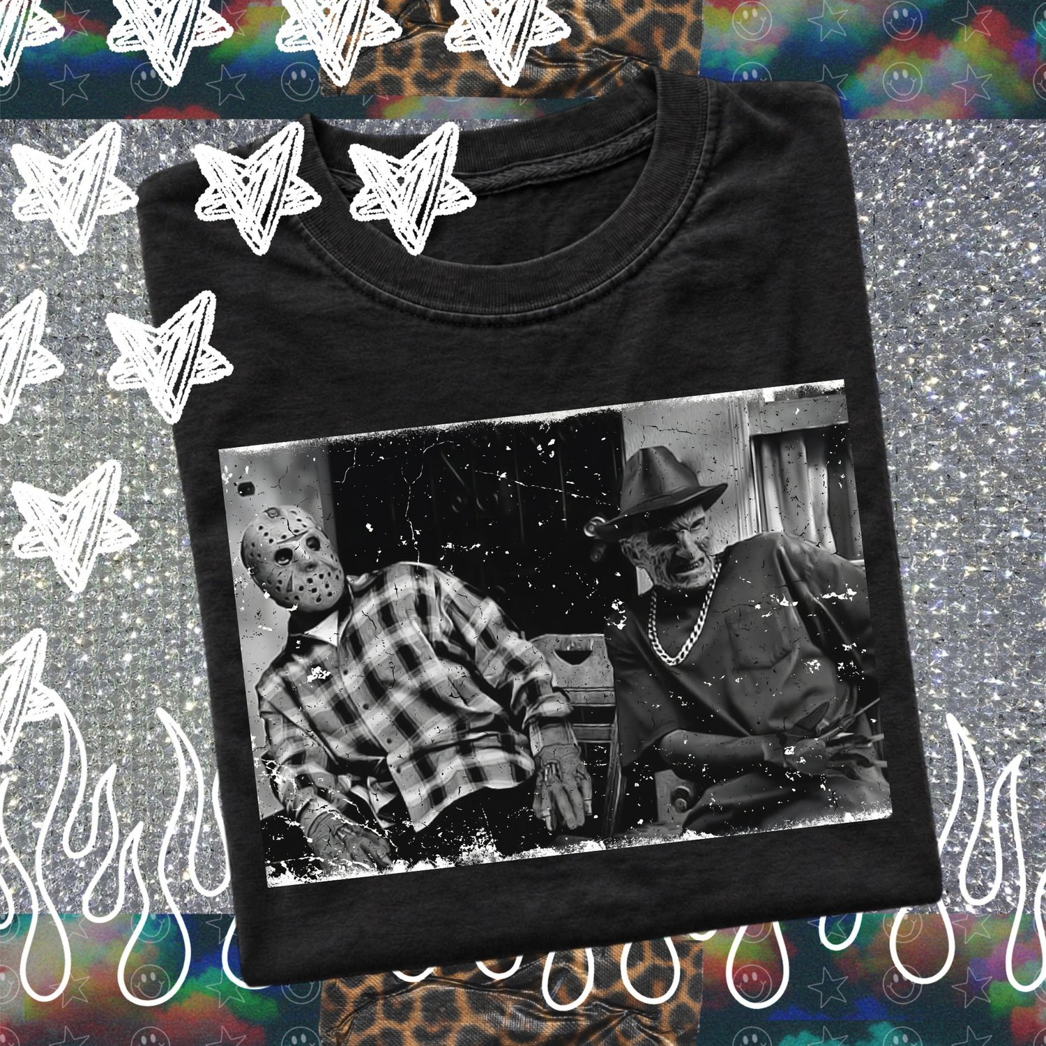 Folded black unisex t-shirt featuring a distressed black-and-white graphic print of horror icons Jason Voorhees and Freddy Krueger sitting together.