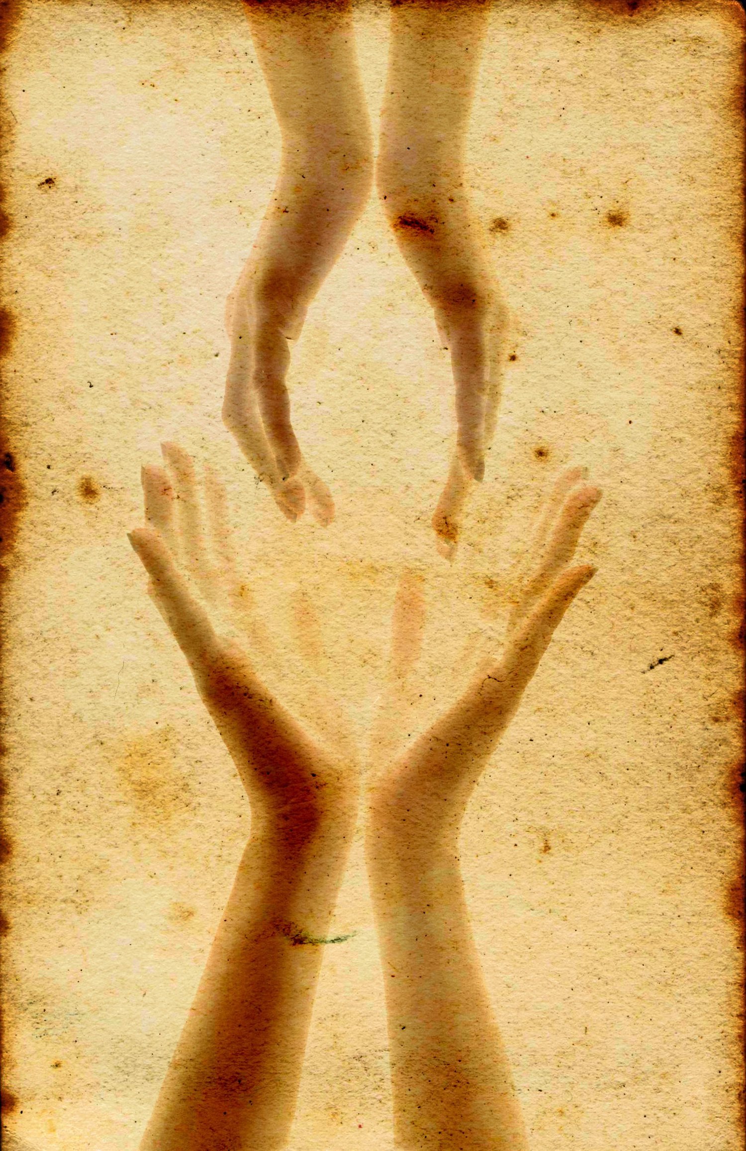 stock photo image depicting two sets of hands reaching for each other; each set shows the hands held together at the wrists with palms facing and open; the top set of hands appears be holding or reaching for something instead of the bottoms set; the photo