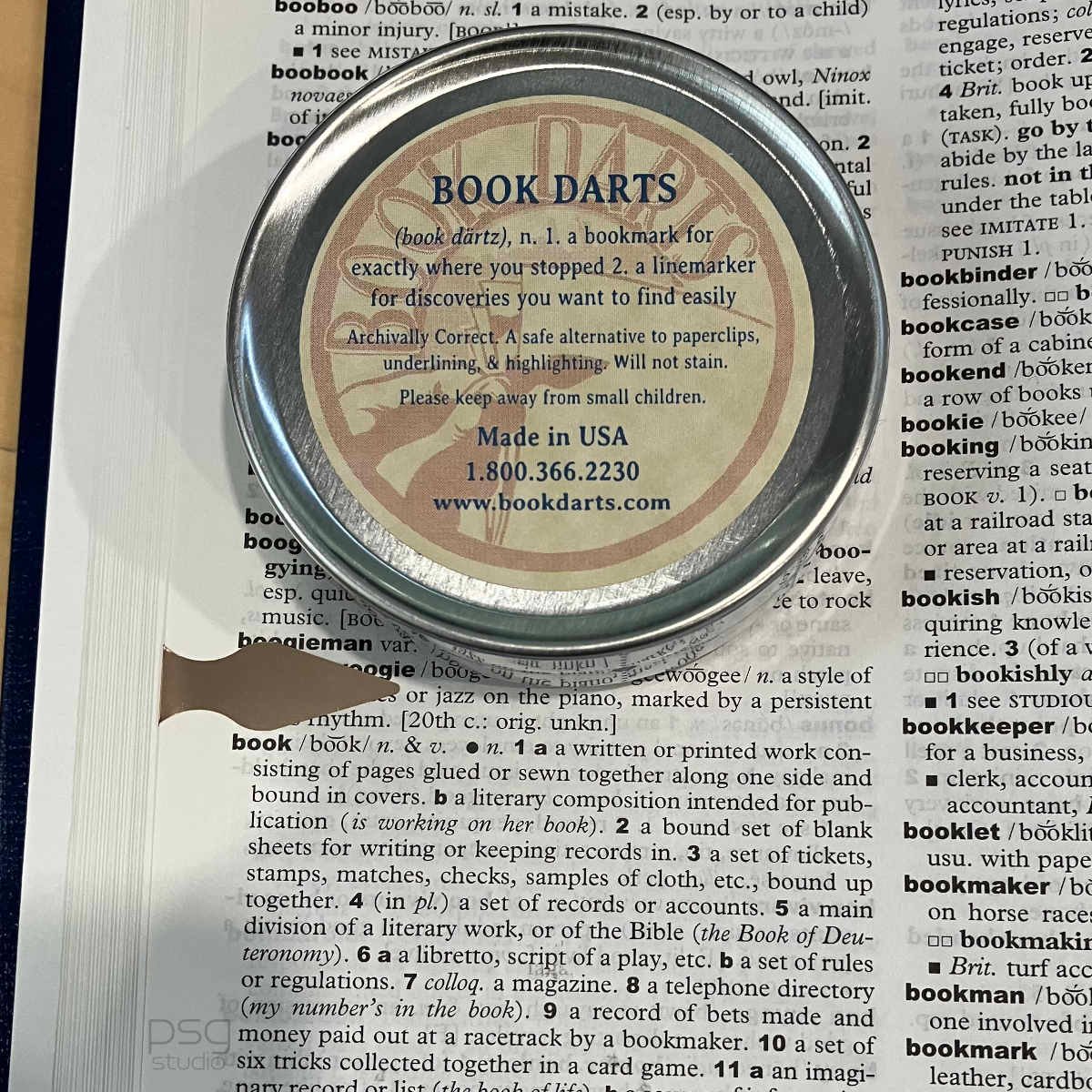 back of book dart tin, shown on a dictionary page