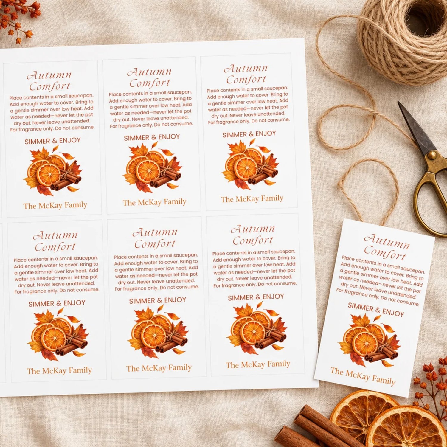 Sheet of eight Autumn Comfort potpourri gift tags with orange slices, cinnamon sticks, fall leaves, simmering instructions, and a family name on white.