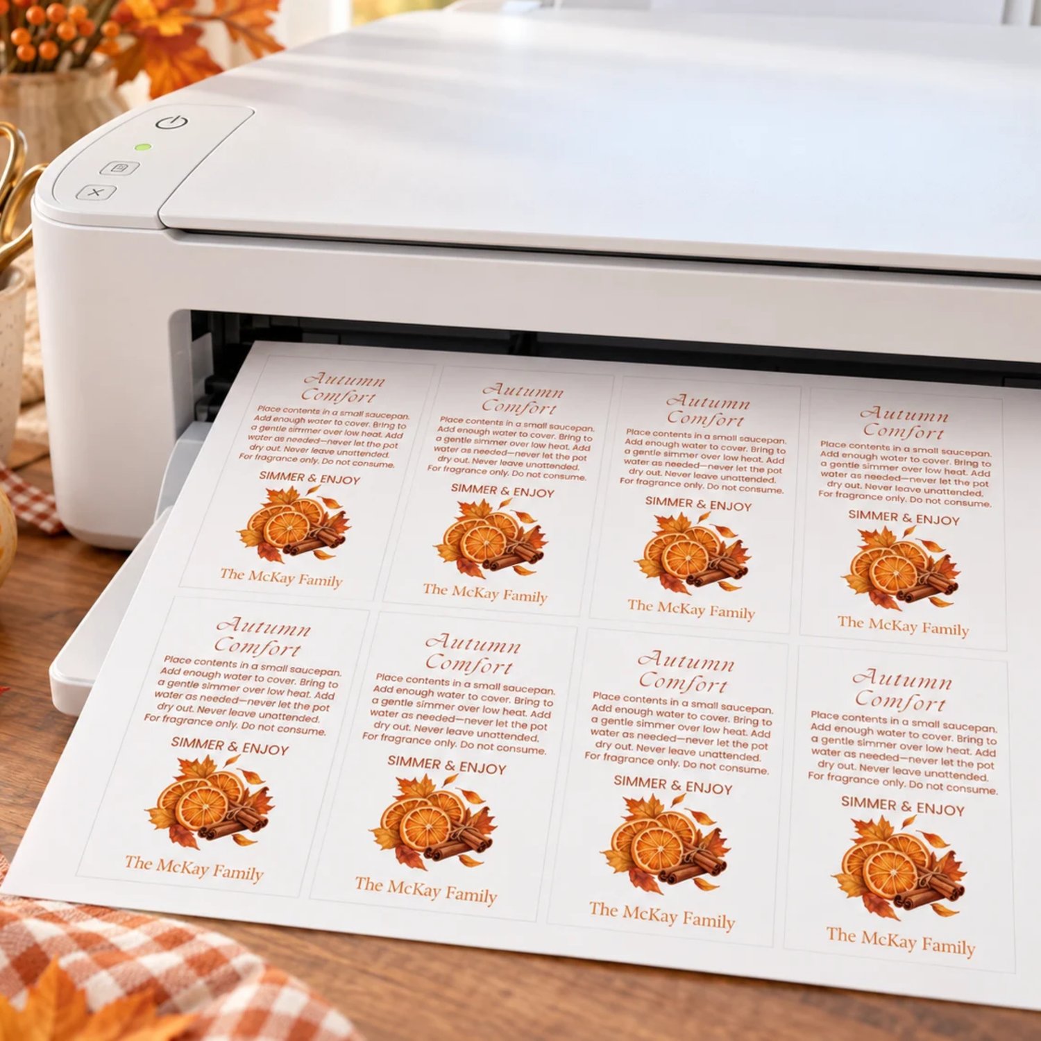 Sheet of eight Autumn Comfort potpourri gift tags with orange slices, cinnamon sticks, fall leaves, simmering instructions, and a family name on white.