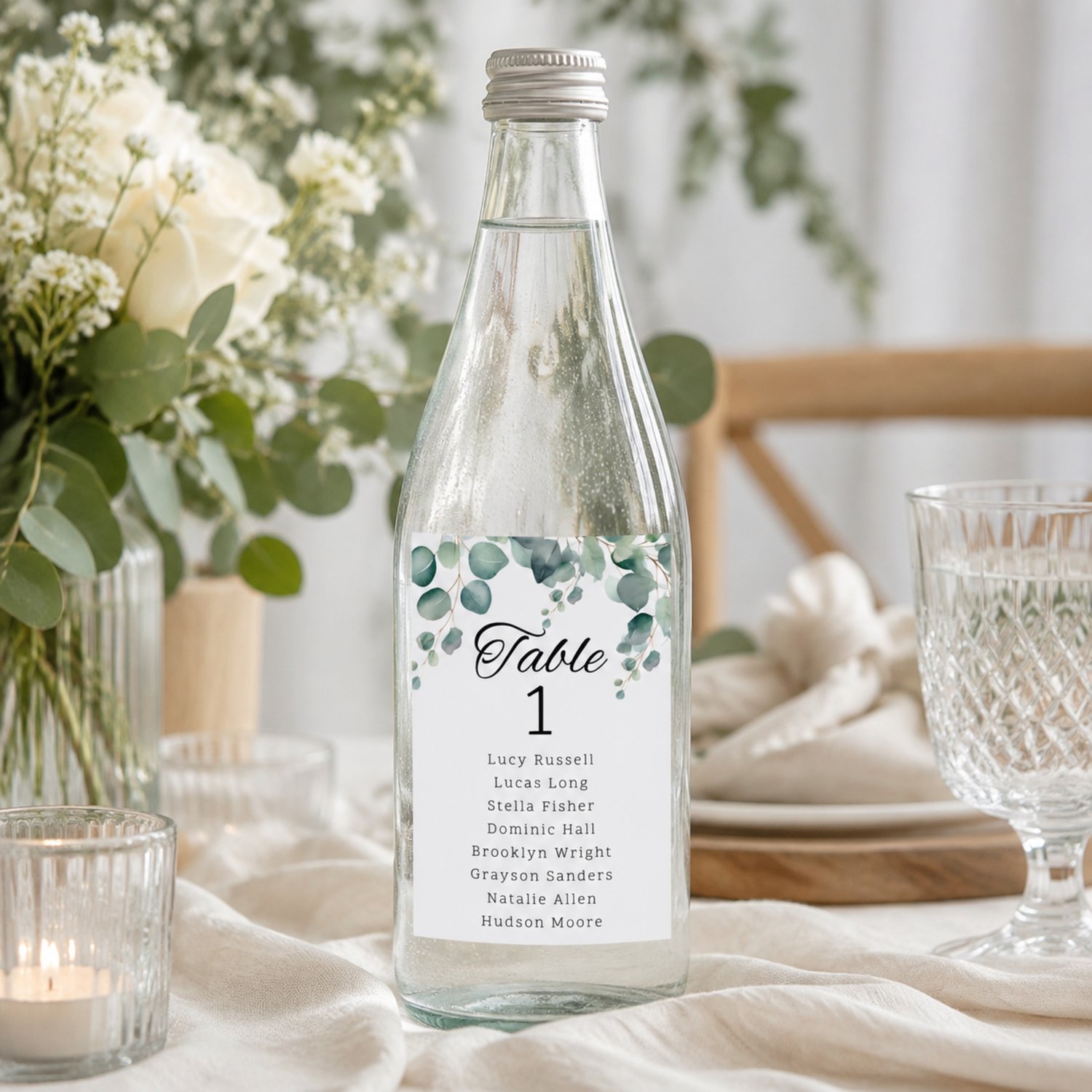 Editable eucalyptus wedding table seating bottle label template featuring watercolor greenery, table numbers and guest names. Includes one 4 by 6 inch rectangular label and a US Letter printing layout with two labels per page for DIY wedding reception déc