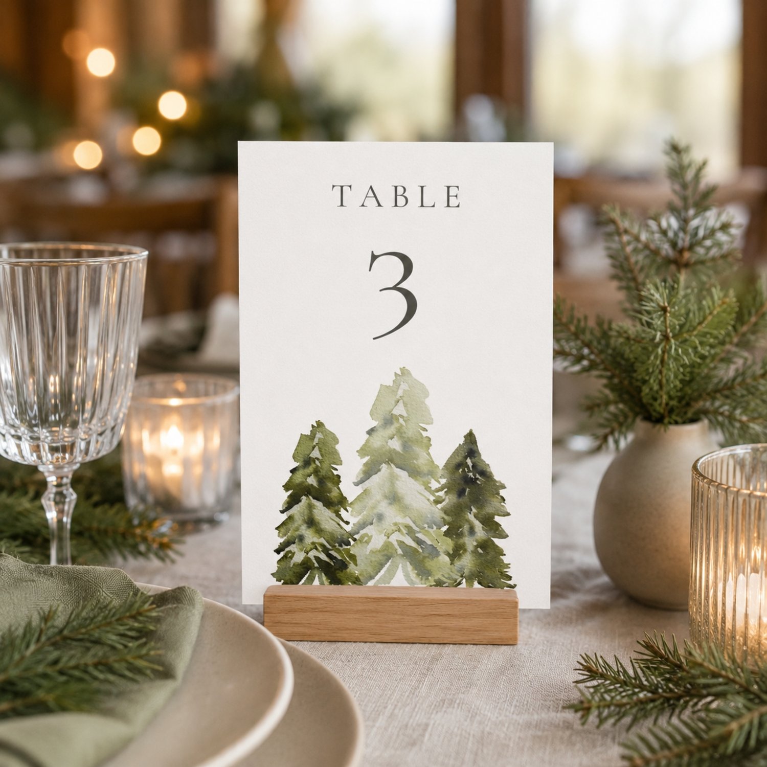 Editable 5 × 7-inch watercolor pine tree table number card featuring soft green woodland trees, elegant charcoal lettering and table numbers 1–30 for rustic, forest, mountain or outdoor weddings.