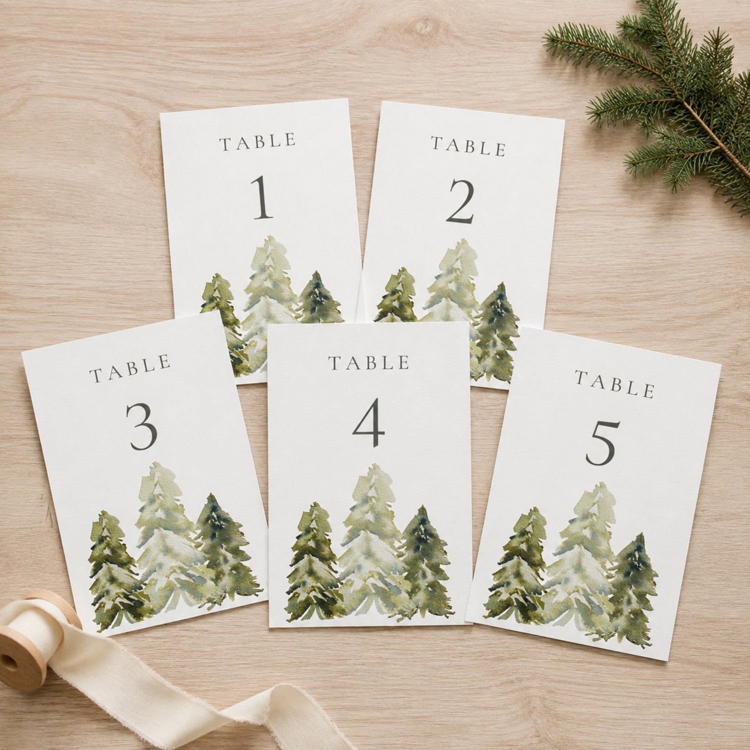 Editable 5 × 7-inch watercolor pine tree table number card featuring soft green woodland trees, elegant charcoal lettering and table numbers 1–30 for rustic, forest, mountain or outdoor weddings.