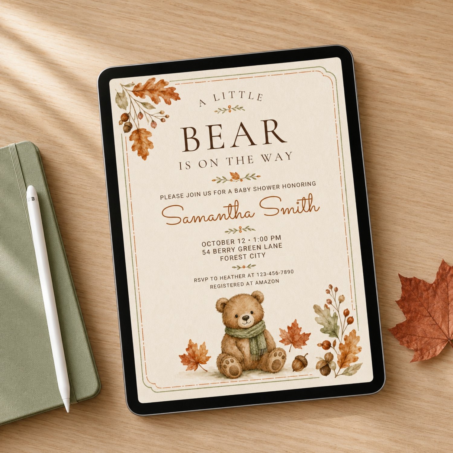 Editable 5 by 7 fall baby shower invitation featuring a watercolor teddy bear in a green scarf, autumn leaves and acorns with “A Little Bear Is on the Way” wording.