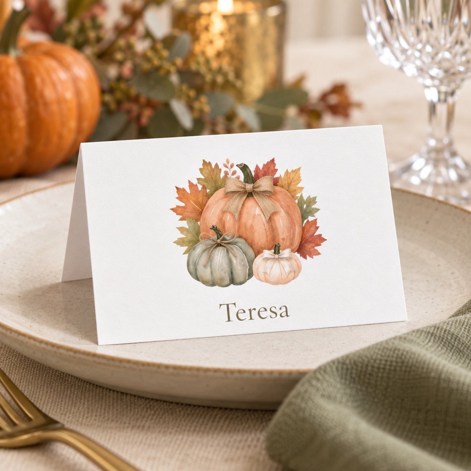 Editable fall place card templates featuring watercolor orange, sage and cream pumpkins with rustic bows and autumn leaves. Includes printable flat and folded tent name cards for Thanksgiving dinners, Friendsgiving and fall celebrations.