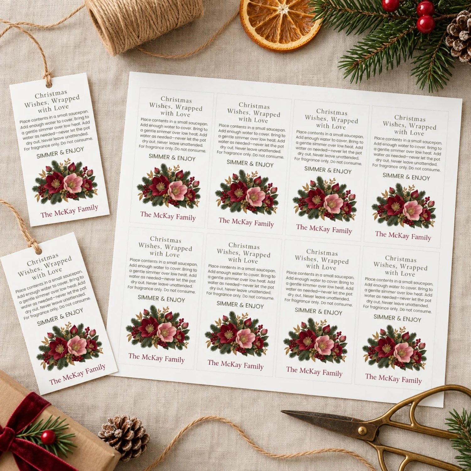 Sheet of eight rectangular Christmas simmer pot gift tags with burgundy and blush flowers, evergreen branches, berries, simmering directions and personalized family name.