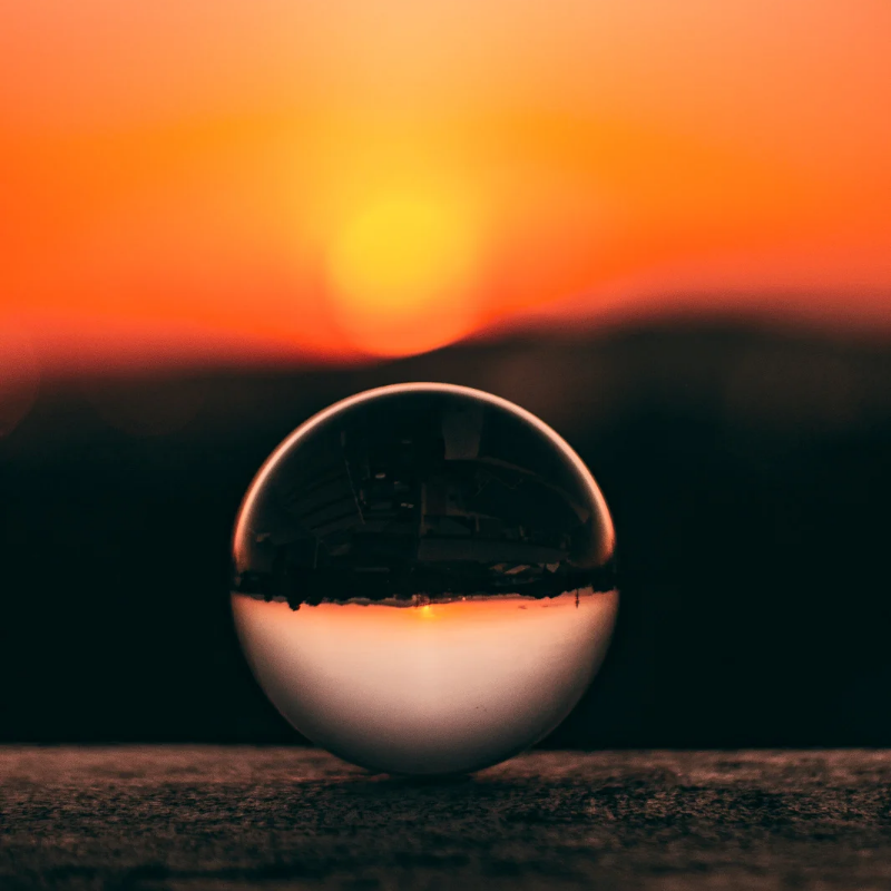 Glass orb on a balcony with sunsut in the background