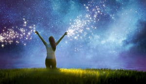 Woman walking into a starry night toward the sea with magical sparkles trailing from her fingertips.