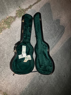 open guitar case with paper money in it