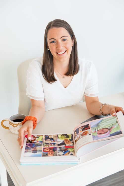 Erin Thompson smiling with a family photo album