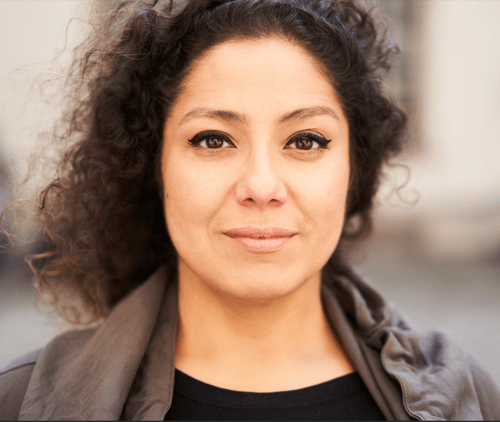 Yvette Gonzalez is the author standing in Southern Germany with her hair blowing in the wind. Photo taken by Marc Bluhm.