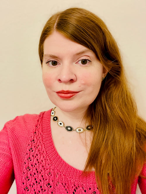 woman wearing pink lace cardigan with asymmetrical neckline