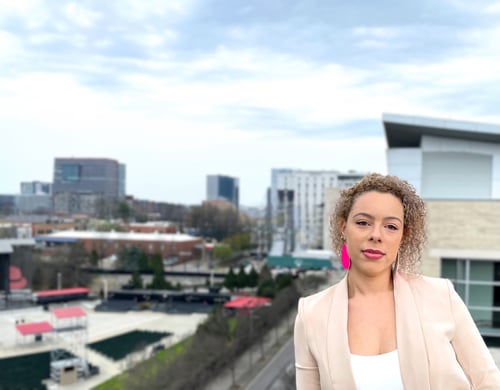 Vanessa Lech standing on top of a parking garage with a city background.
