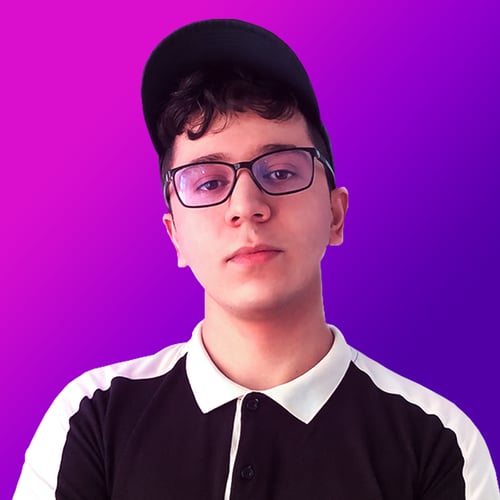 Professional headshot of graphic designer and brand identity specialist Vance Verlice. He stands against a vibrant purple and magenta gradient background, wearing glasses, a black cap, and a black-and-white collared shirt, reflecting his creative style and expertise in visual branding.