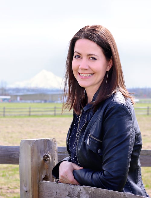 Kris Maze author standing in front of a mountain in a field