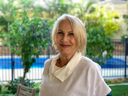 photo of older woman, wearing a white blouse and smiling