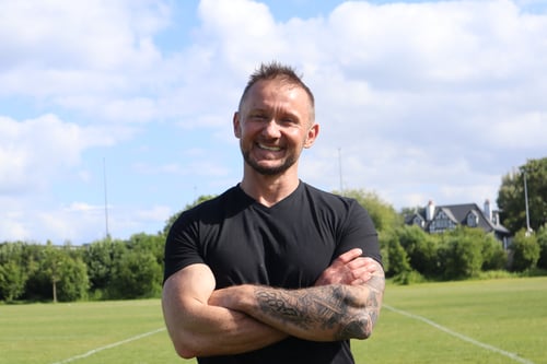 Jason Cafferkey, running coach and speed development trainer in Galway, in sprint start position on a red running track, preparing for explosive speed training for athletes, GAA Athletes, busy moms, busy dads, fitness clients.