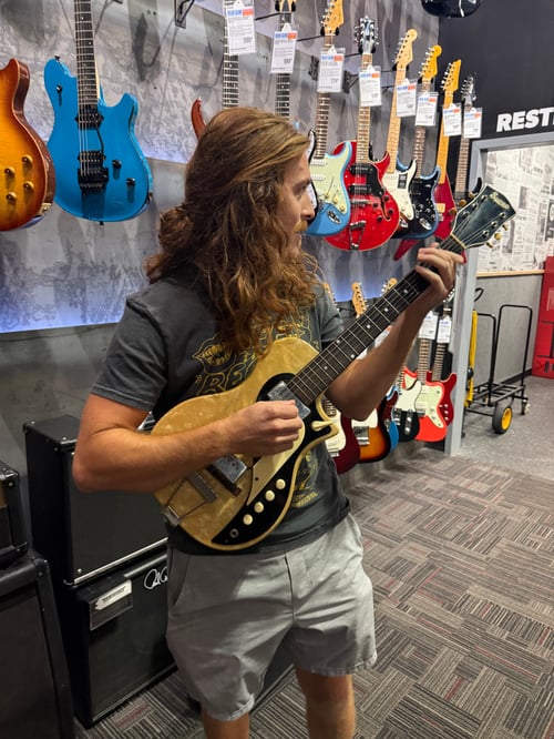 Clayton playing a vintage Supro Dual-Tone guitar in Guitar Center