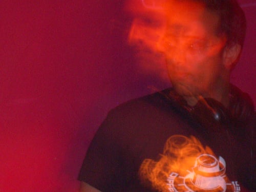 Motion blurred picture of dj hari behind decks