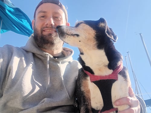 Smiling alongside my dog outdoors on a beautiful sunny day.