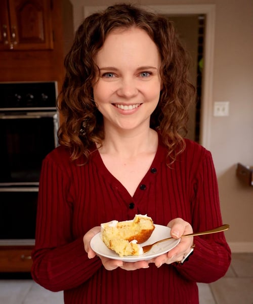 Kelsey Smith holding a small dessert plate with a piece of cake.