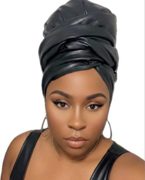 Annesty Gray, founder of CRWNLX ((pronounced CROWN-licks), wearing a black faux leather wrapped turban skin over a silk-lined headwrap.