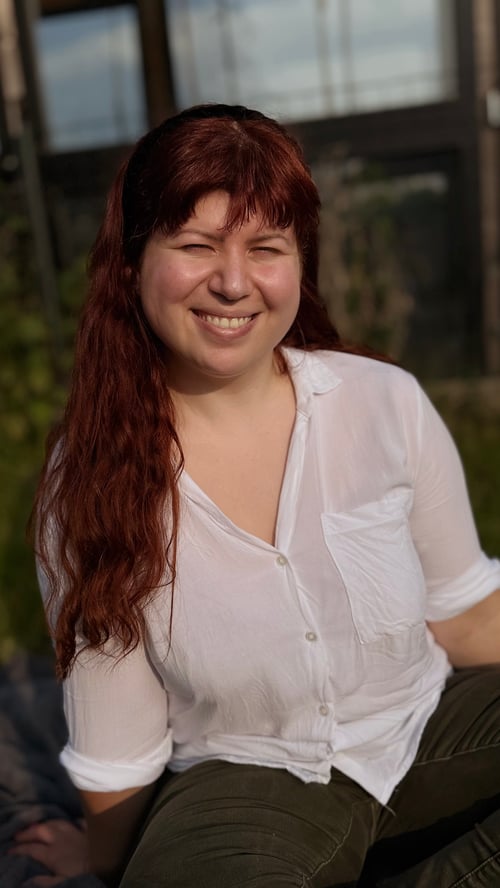 Porträt von Jenny, der Gründerin von jennysbuntesleben, mit langen roten Haaren und einer weißen Bluse.