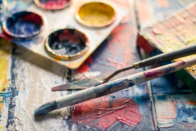 paintbrushes near paint pallets